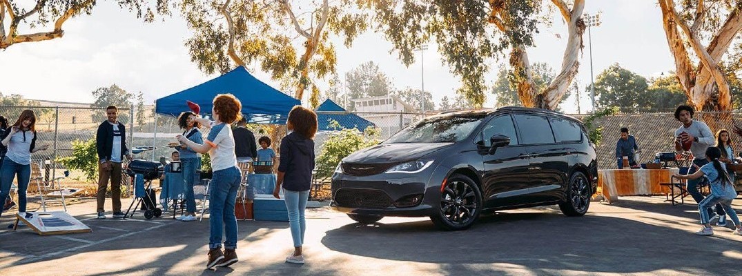2020 Chrysler Pacifica black parked in parking lot of park with tents and people