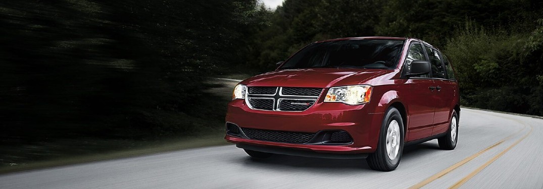 2020 Dodge Grand Caravan red driving on white road through forest