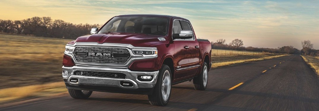 2020 Ram 1500 dark red paint driving on country road toward shot at sunset showing front bumper and driver side doors
