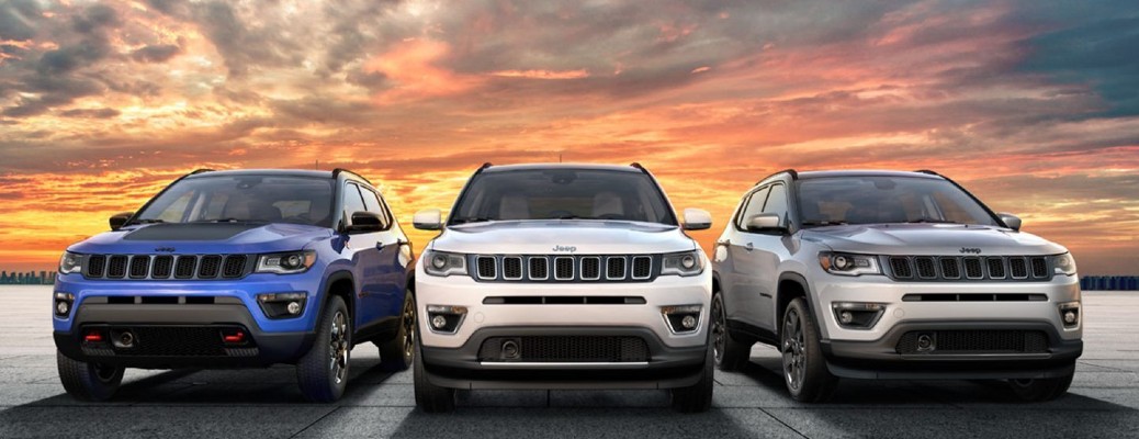 2020 Jeep Compass set of three blue white and gray parked on flat in front of sunset