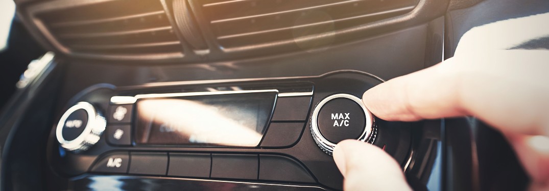 stock photo of hand turning A_C knob under air vents