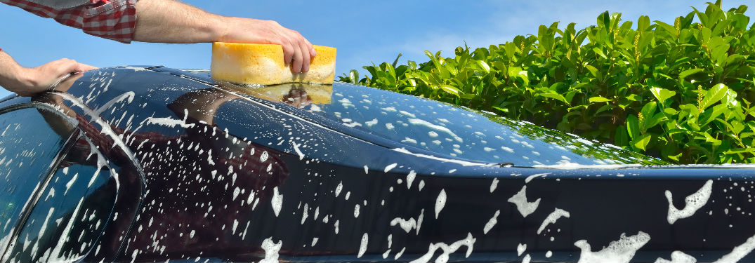 hands washing a car outside