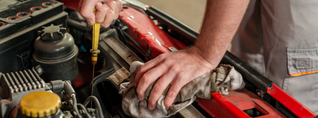 Mechanic checking oil in a used vehicle engine