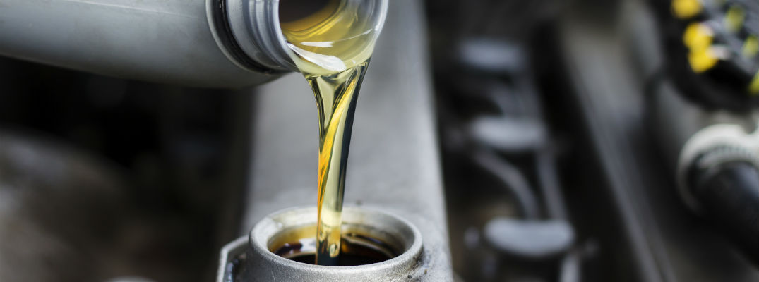 A stock photo of oil being poured into an engine.