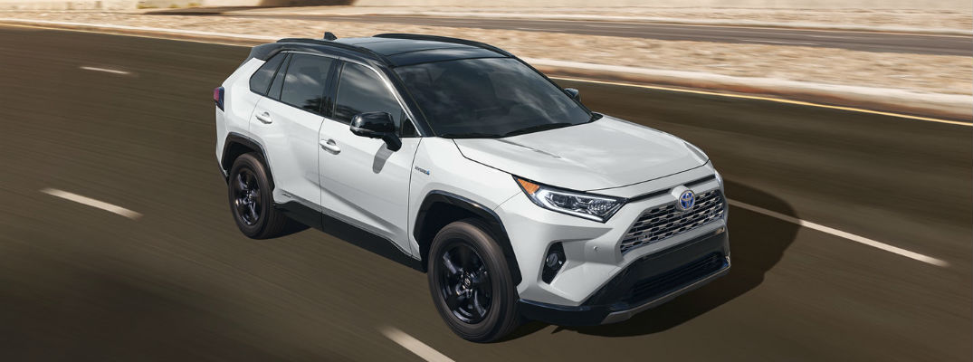 A front right quarter photo of the 2020 Toyota RAV4 Hybrid in motion on the road.