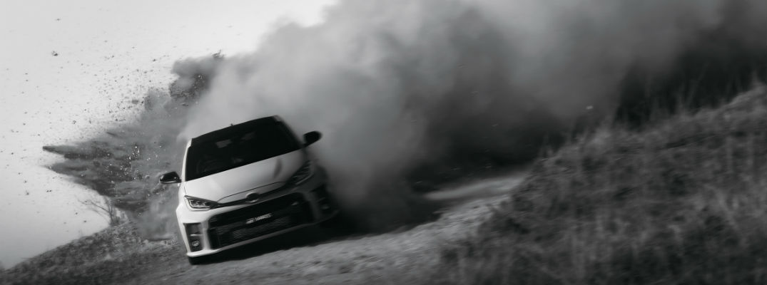 A photo of the Toyota GR Yaris drifting around a dirt track.