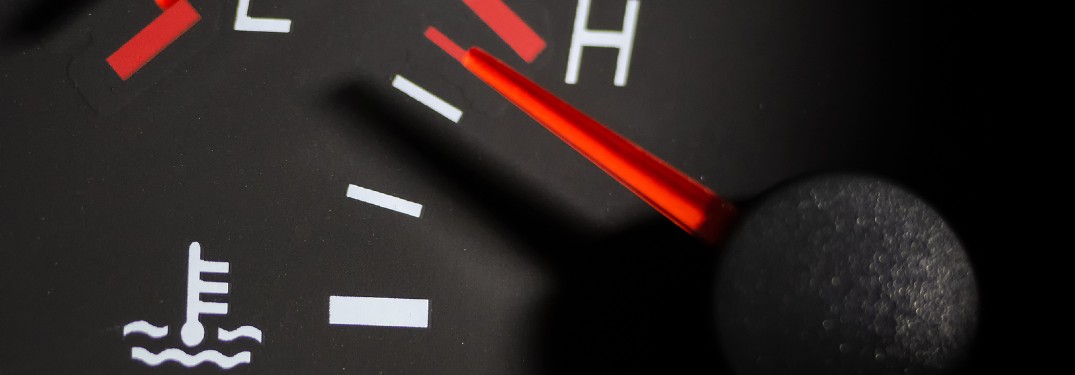 Close up of a temperature gauge spiking to the red inside a car