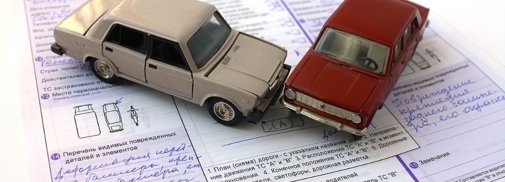 two miniature cars over an insurance or some kind of agreement