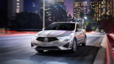 Front driver angle of a silver 2020 Acura ILX driving in a city