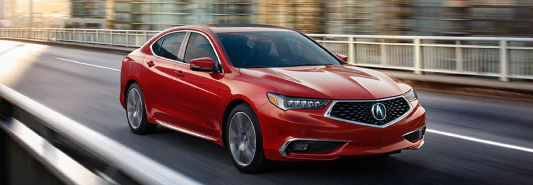 Front passenger angle of a red 2020 Acura TLX driving on a road