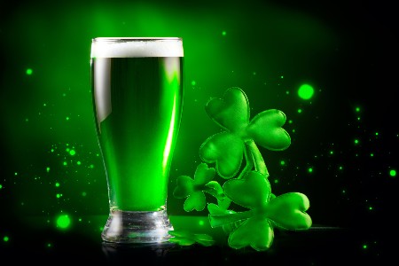 Graphic of a pint of green beer with clovers next to it