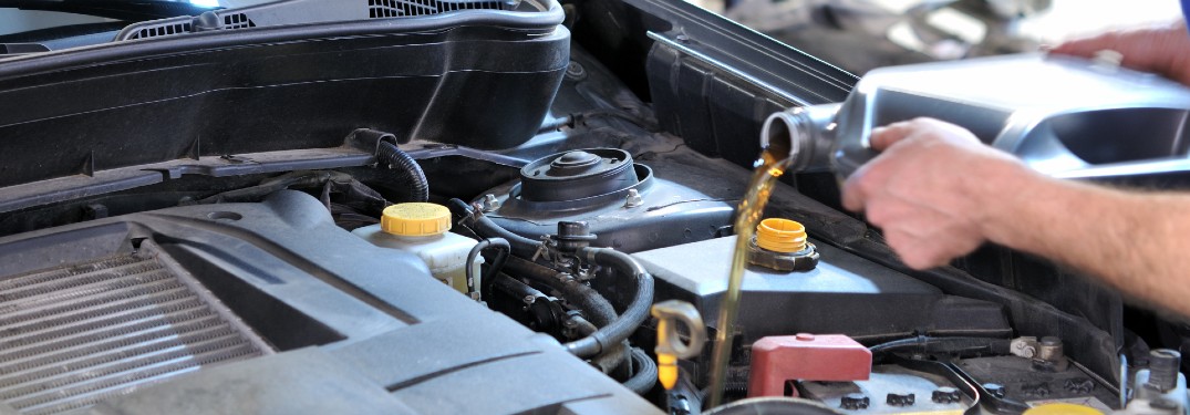 Mechanic filling an engine with oil