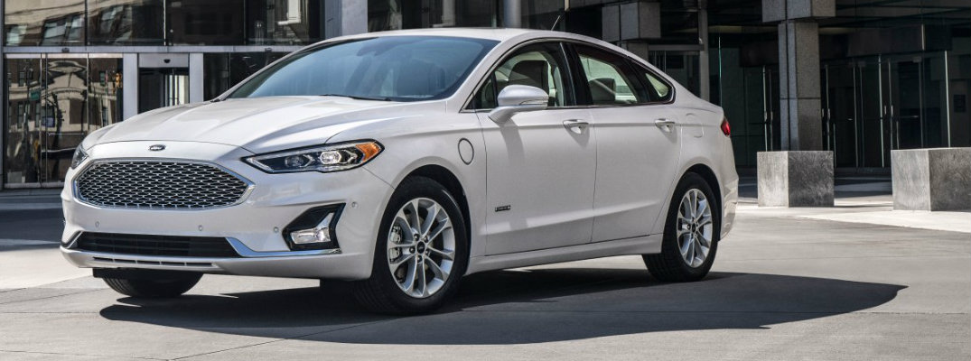Profile view of white 2019 Ford Fusion driving on city street