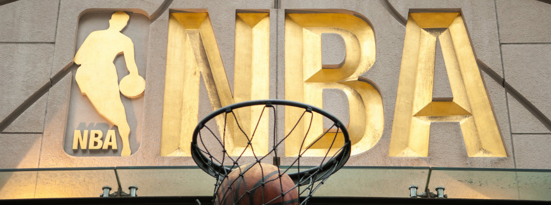 Gold NBA logo with basketball going through hoop underneath