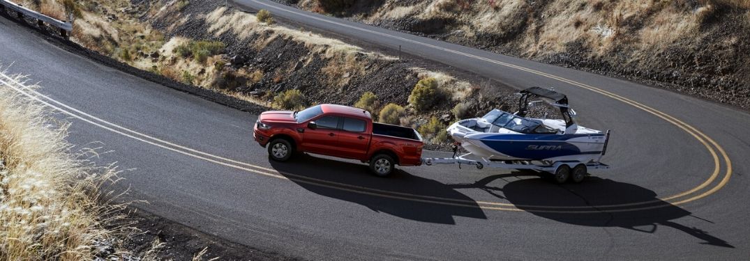 Exterior view of a red 2020 Ford Ranger towing a boat