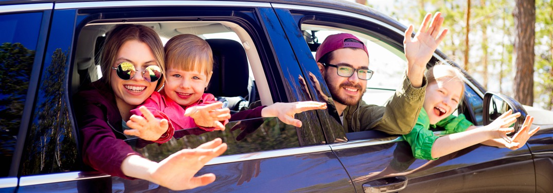 family waving out of car