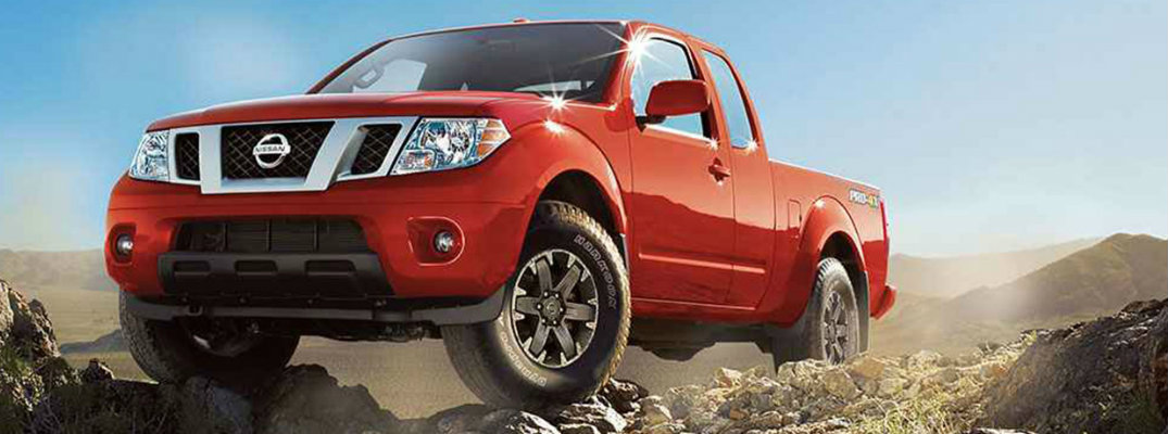 View of red 2018 Nissan Frontier driving over rocky surfaces