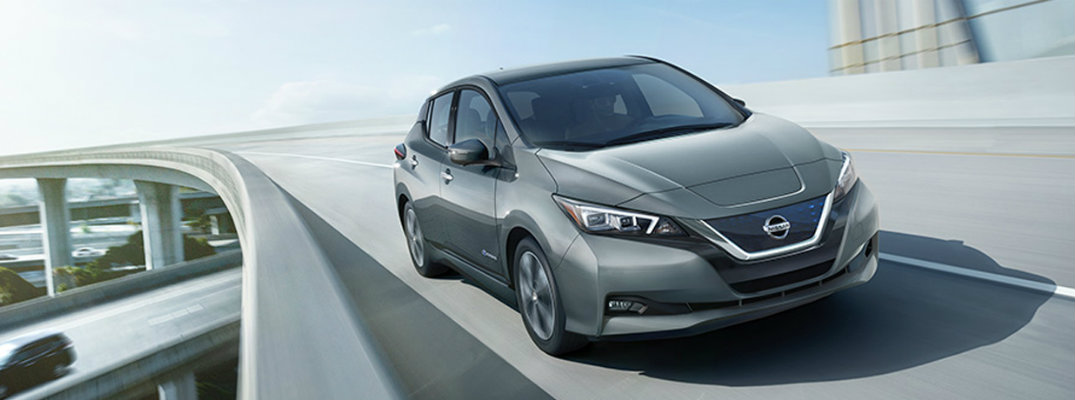 Exterior view of silver 2018 Nissan LEAF driving down an elevated highway