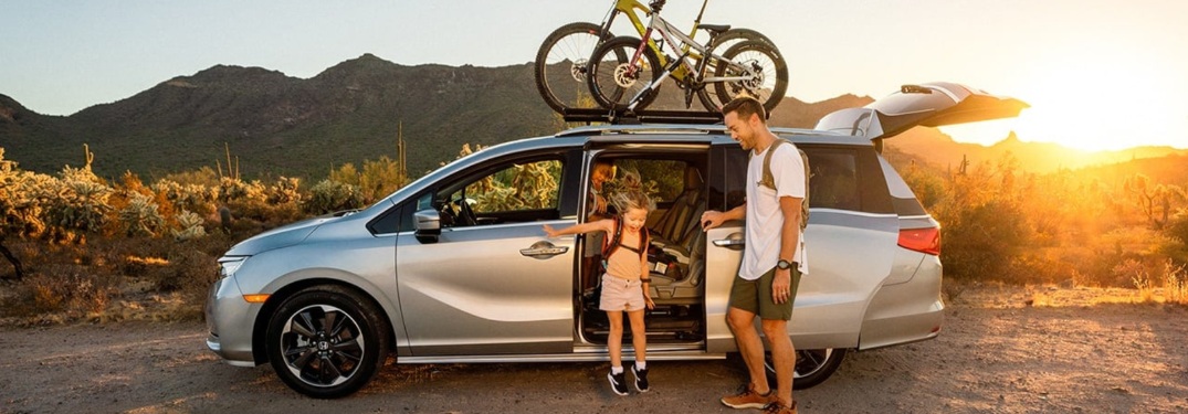 2021 Honda Odyssey with bikes on top and dad and daughter