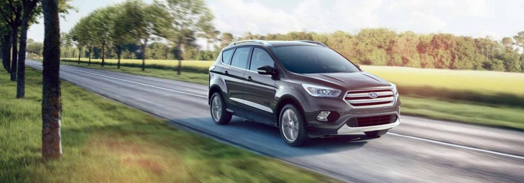 2018 Ford Escape driving quickly on an open highway by a field