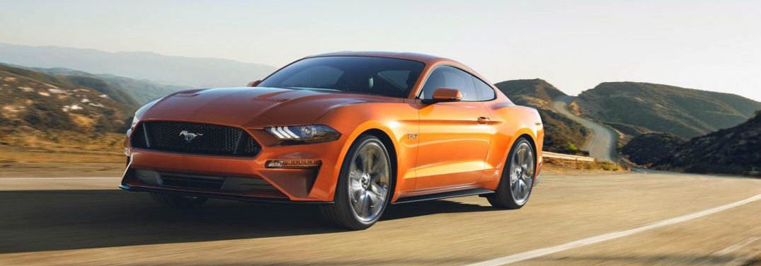 2018 Ford Mustang in Orange Fury driving on a highway