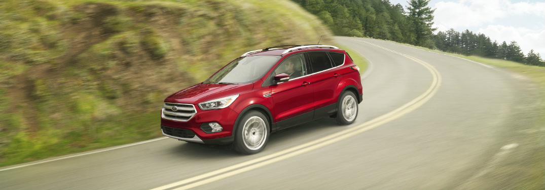 front and side view of red 2018 ford escape driving on road downhill