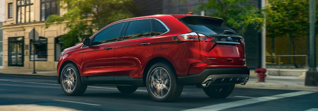 rear and side view of red 2019 ford edge driving on city street