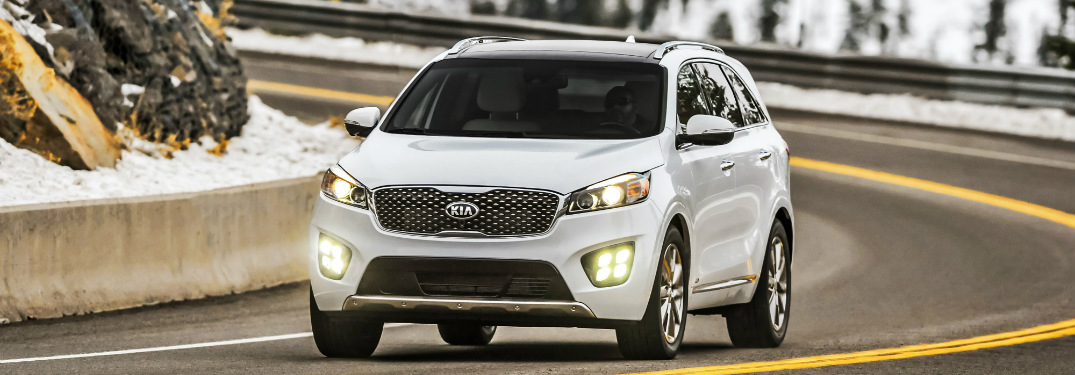 white 2018 kia sorento driving on road in snowy mountains