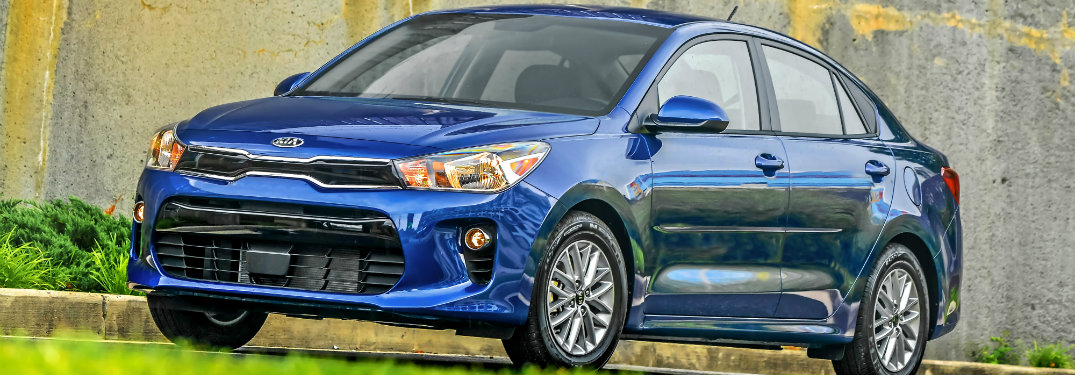 blue 2018 kia rio against concrete wall