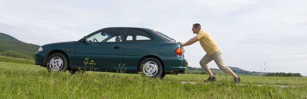 man pushing a car