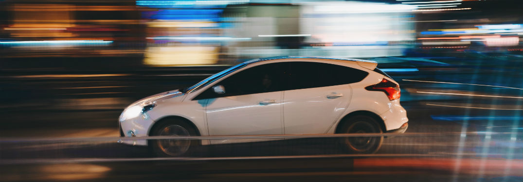 generic car driving through a city at night