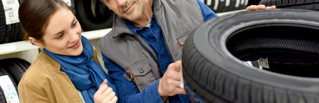 man and woman looking at tires