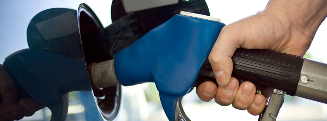 A stock photo of a person filling their car with gasoline.