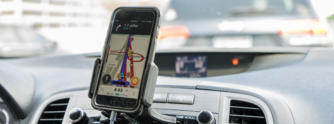 A photo of a smartphone attached to a dashboard showing navigation information.