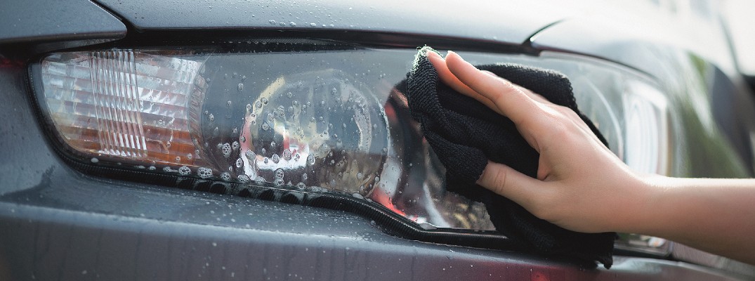 A stock photo of a person shining a headlight lens.