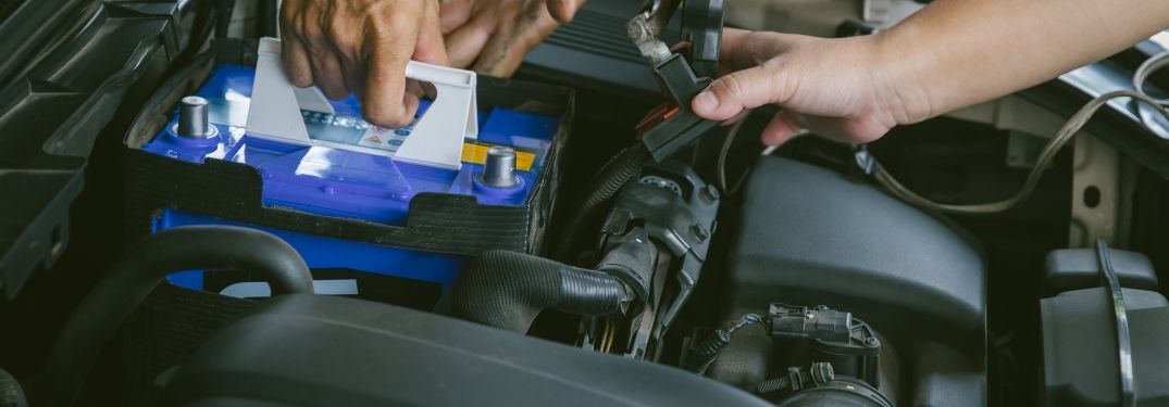 A technician placing a new battery into the slot