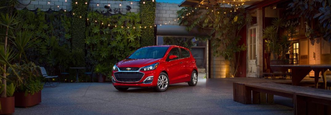 A red 2021 Chevrolet Spark parked outside a house.