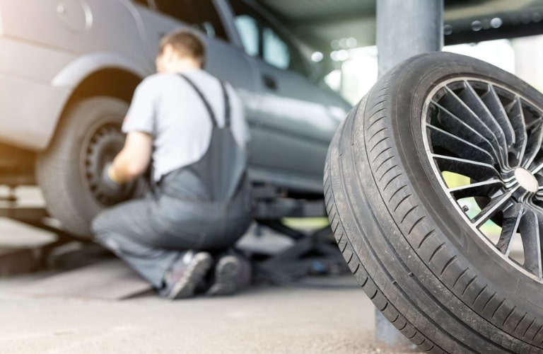 Technician checking a vehicle's tire