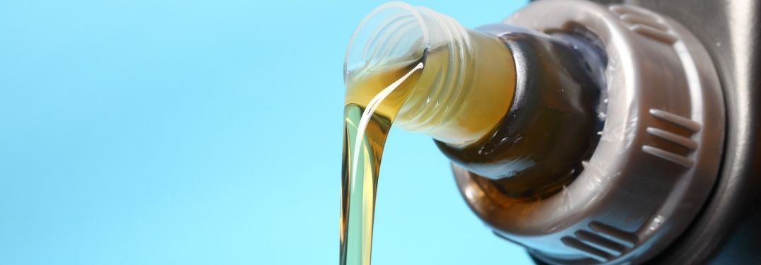 Pouring down oil from a bottle.
