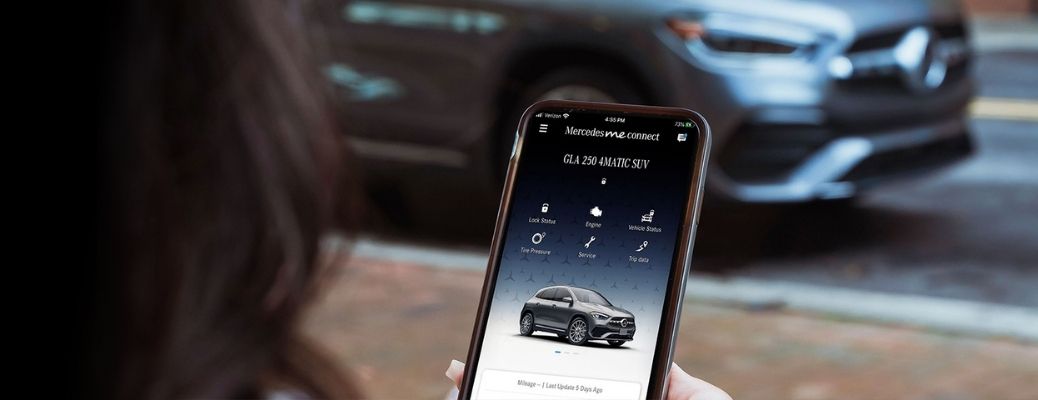 Image showing a woman using the Mercedes me connect app on her smartphone