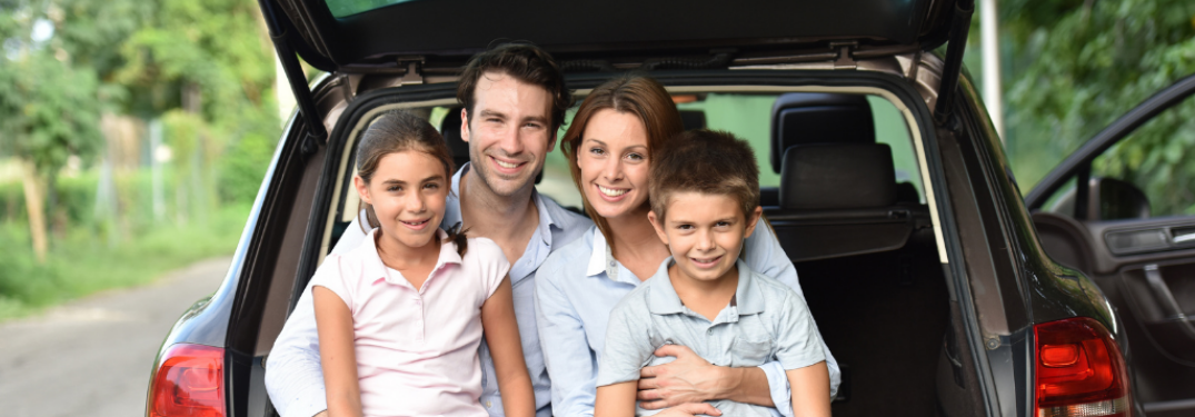 Family sitting at the back of a car