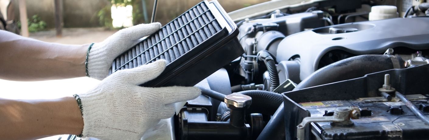 A mechanic inspecting a car's engine air filter