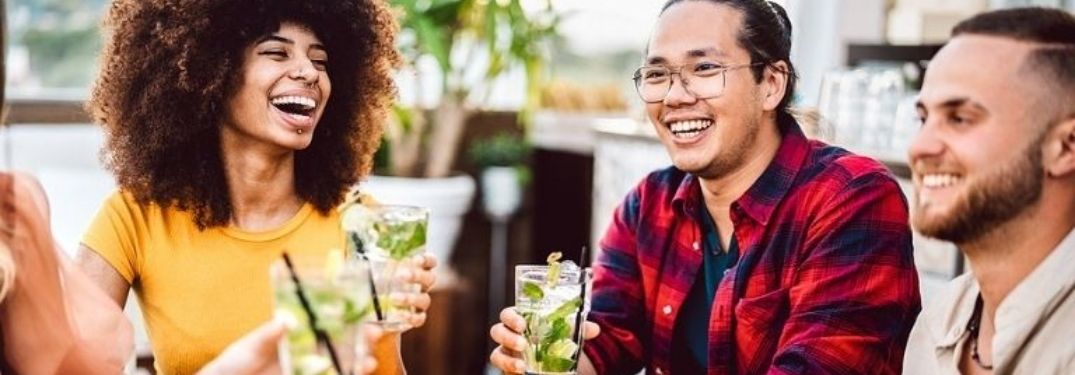 A woman and two women enjoying drinks.