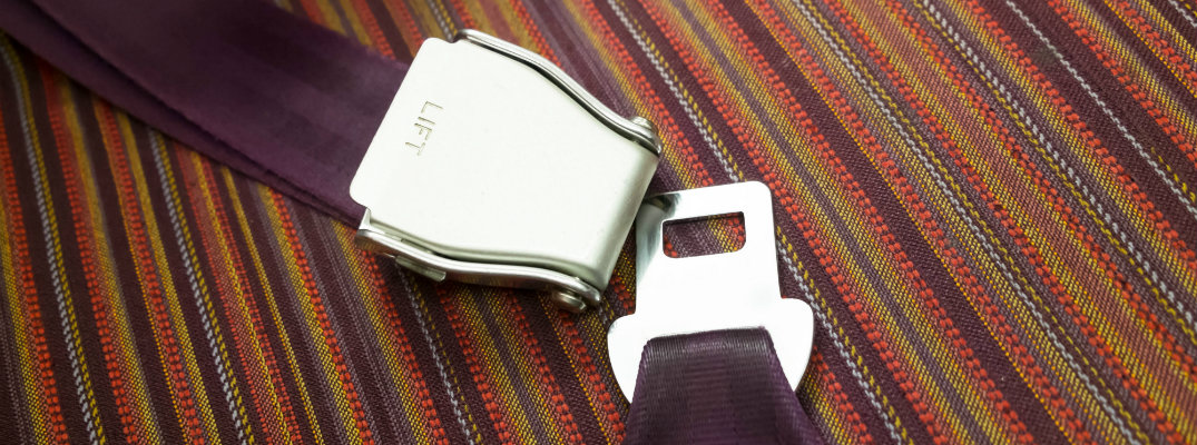 purple seat belt latches set atop a colorful floor carpet