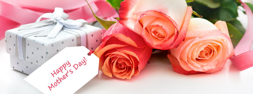 happy mother's day card next to a bouquet of flowers and a wrapped present
