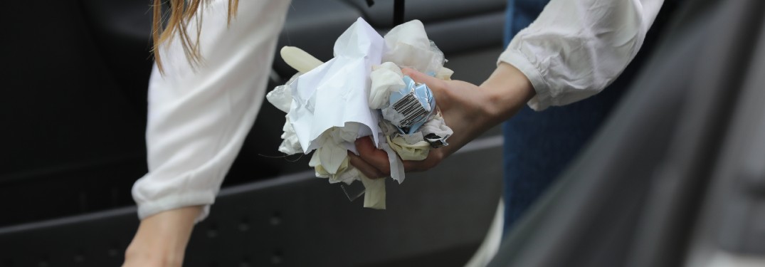 woman taking garbage out of her car