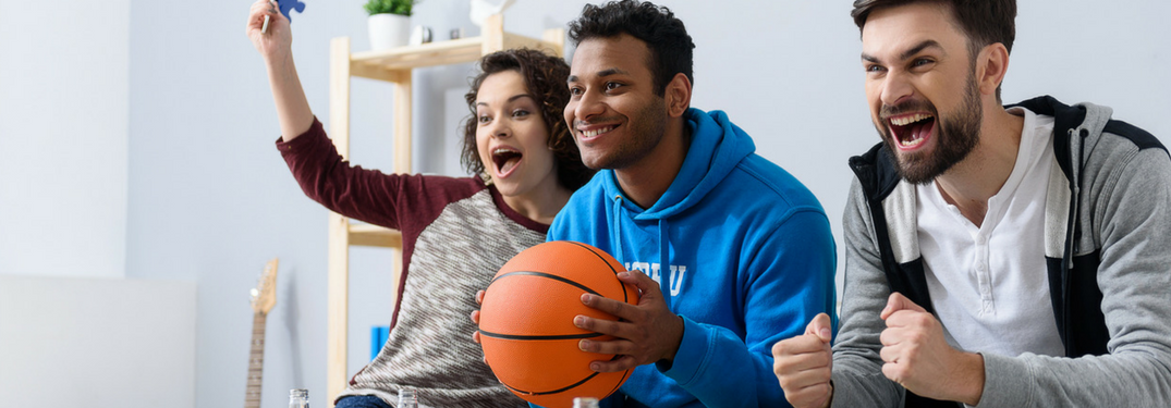 Friends watch basketball on a couch