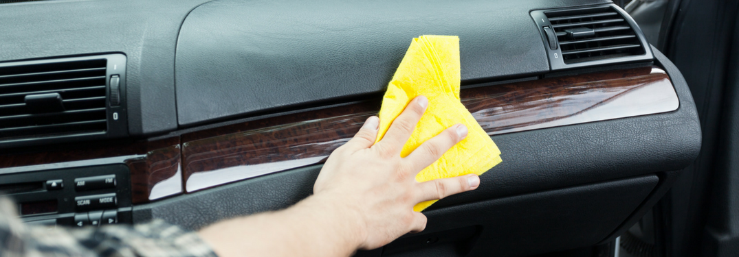 man wipes down dashboard