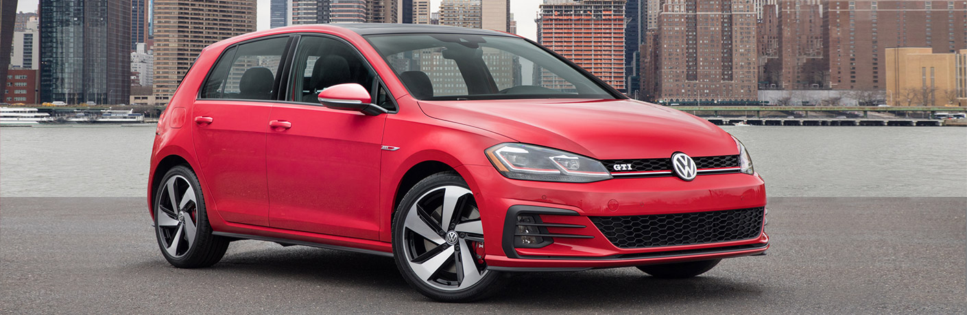 Red 2018 Volkswagen Golf GTI parked on the road in front of a building
