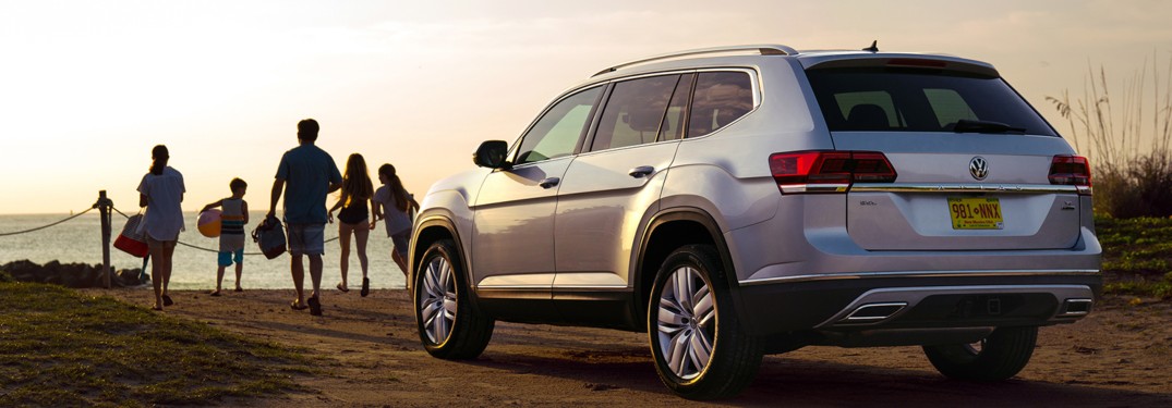 2019 Volkswagen Atlas parked on a beach with a family nearby
